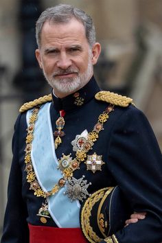 an older man in uniform with a beard and mustache, standing on the steps of buckingham palace