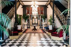 the lobby is decorated in black and white checkered flooring, with chandeliers hanging from the ceiling