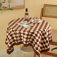 a table with a checkered cloth on it and a bottle of whiskey sitting on top