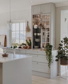 a kitchen filled with lots of white counter tops and cabinets next to a dining room table