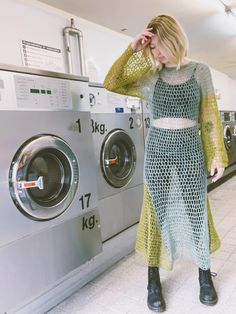 a woman standing in front of a washing machine