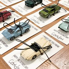 many toy cars are on cards with string attached to them