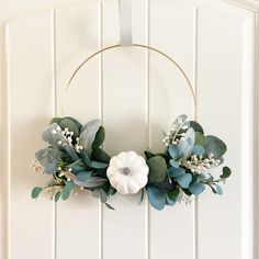 a wreath with flowers and greenery hangs on the wall