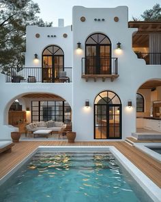 a house with a pool in front of it and lots of windows on the side