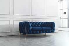 a blue couch sitting on top of a white floor next to a large window in an empty room