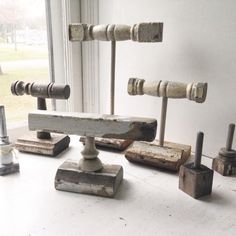 an assortment of wooden objects sitting on top of a white table next to a window