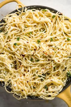 a skillet filled with spaghetti and vegetables