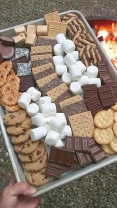 a metal tray filled with marshmallows, crackers and grahamy cookies