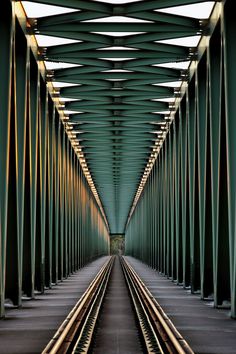 an image of a train track that is going through the middle of a tunnel with lots of poles