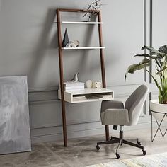 a room with a chair, desk and shelves on the wall next to a potted plant