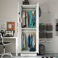 a white closet with clothes hanging on it