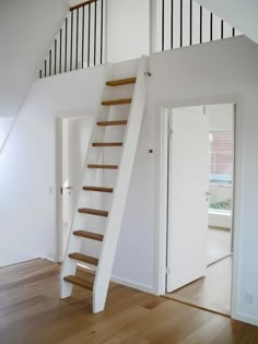 there is a stair case in the middle of this room with wood floors and white walls