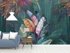 a living room with a blue couch and wall mural featuring tropical leaves on the walls