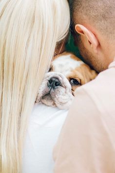 a man and woman cuddle with their dog