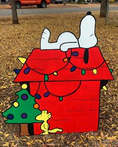 a cardboard house with snoopy and christmas lights on it