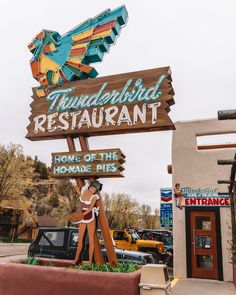 a sign for thunderbird restaurant in front of a building with cars parked around it