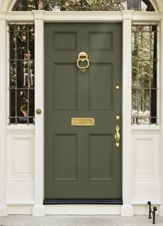 a green front door with two windows and a gold knocker on the side entrance