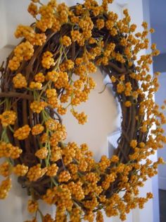 a wreath with yellow flowers hanging on the wall