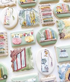 many decorated cookies are arranged on a table top, including one with an image of a bookcase