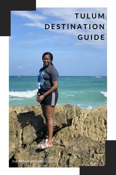 a woman standing on top of a rock next to the ocean