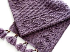 two purple knitted scarves with tassels