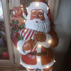 a statue of santa holding a candy cane