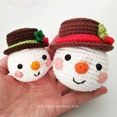 two crocheted snowmen with hats on their heads are shown in the palm of someone's hand