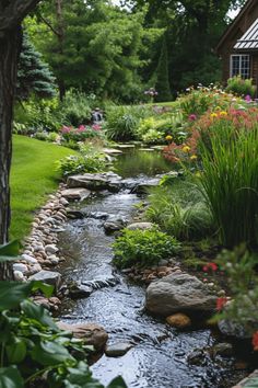 a small stream running through a lush green forest filled with lots of flowers and greenery