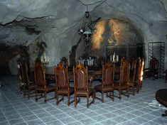 a dining room table and chairs in a cave like setting