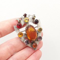 DESCRIPTION: A very good quality and large antique Victorian Scottish shield brooch. The brooch is adorned with a large citrine paste centre and numerous smaller citrine, amethyst and garnet pastes. The brooch isn't hallmarked (which is typical of antique Scottish jewellery) but tests for sterling silver. It weighs approx 15.22g and the size dimensions are in the later photos. As to be expected with age and use, some of the pastes have marks and scratches on them, see pictures/video. There are s Ornate Gemstone Brooches For Collectors, Antique Multi-stone Brooches For Formal Occasions, Antique Multi-stone Brooches For Wedding, Scottish Shield, 1800s Jewelry, Amethyst And Garnet, Scottish Jewellery, Jewellery Vintage, Fantasy Races