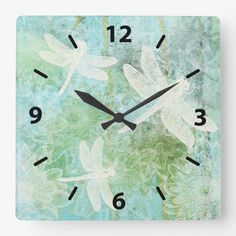 a square clock with dragonflies on it