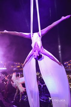 a woman is performing aerial acrobatic tricks on stage