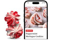 a cell phone next to a red and white peppermint meringue cookies