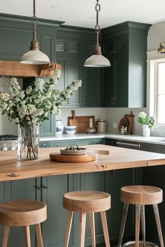 a kitchen with green cabinets and wooden stools