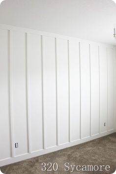 an empty room with white paneling on the walls