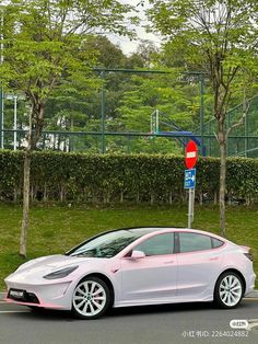 a white car parked in front of a parking meter on the side of a road