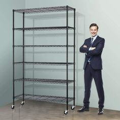 a man in a suit standing next to a rack with shelves on wheels and one holding his arms crossed