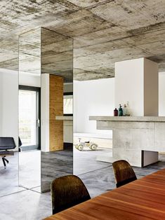 an empty conference room with wooden tables and chairs in front of a large mirror wall