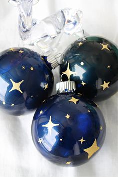 three shiny blue and gold christmas ornaments