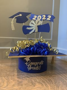 a blue graduation hat with gold confetti and congratulations graduate's cake topper