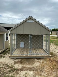 a dog kennel in the middle of a dirt lot