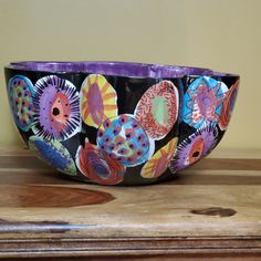 a colorful bowl sitting on top of a wooden table