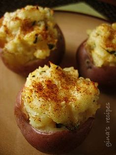 three baked potatoes with cheese and seasoning sprinkled on top