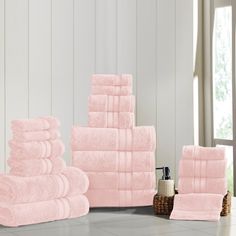 a stack of pink towels sitting on top of a bathroom floor