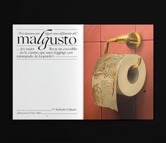 an open magazine with a roll of toilet paper hanging on the wall