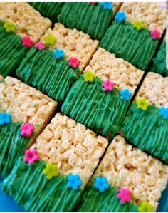 rice krispy treats with green frosting and flowers on them are arranged in the shape of squares