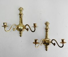 two brass wall lights on a white wall