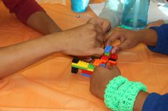 several people are playing with legos on a table