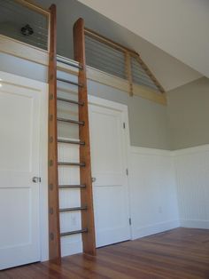 an empty room with two doors and a ladder