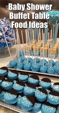 baby shower buffet table with blue and black cupcakes, cake pops, and candy sticks